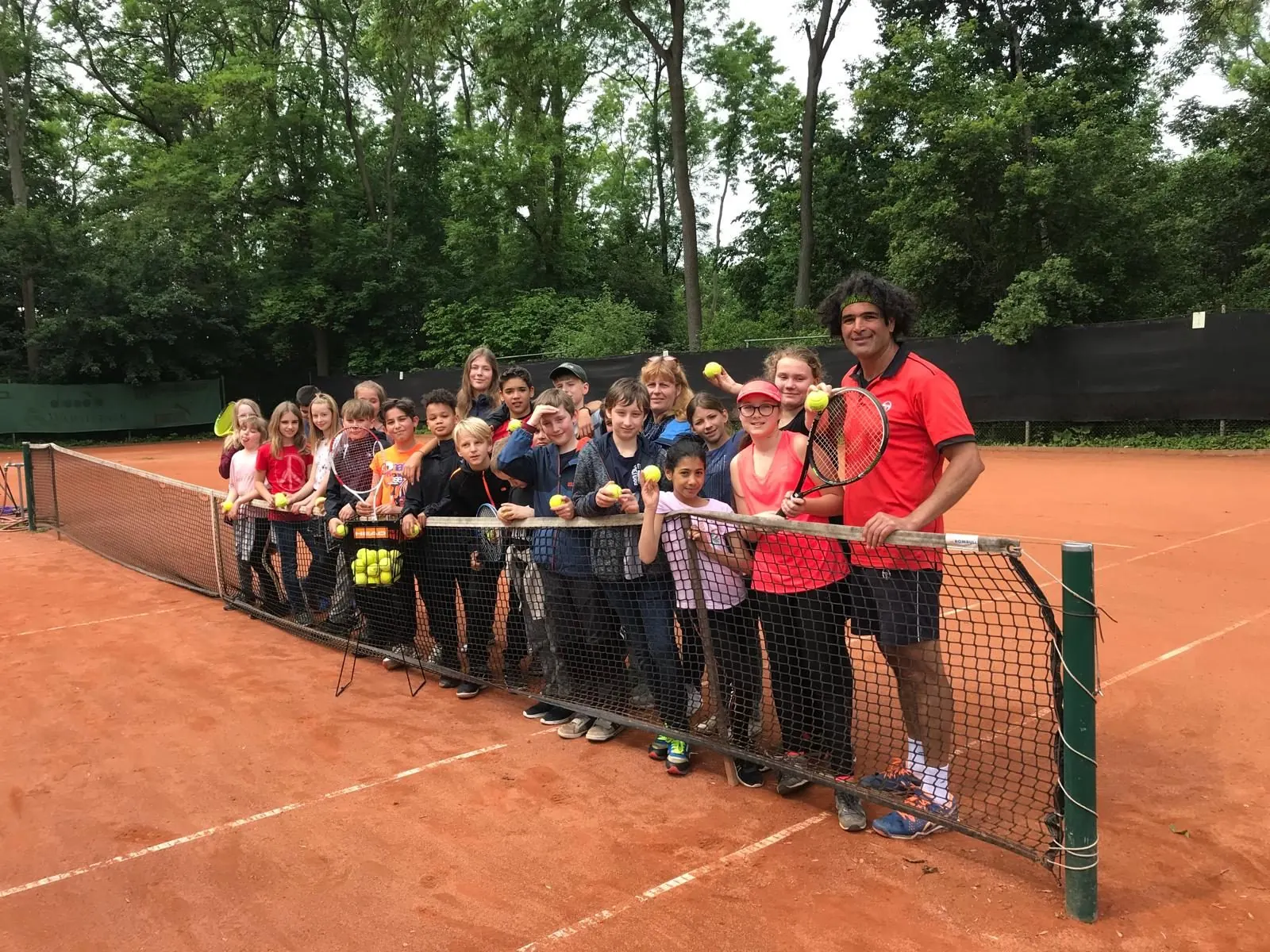 Gruppenfoto im Sommercamp mit Trainer Shahin am Netz