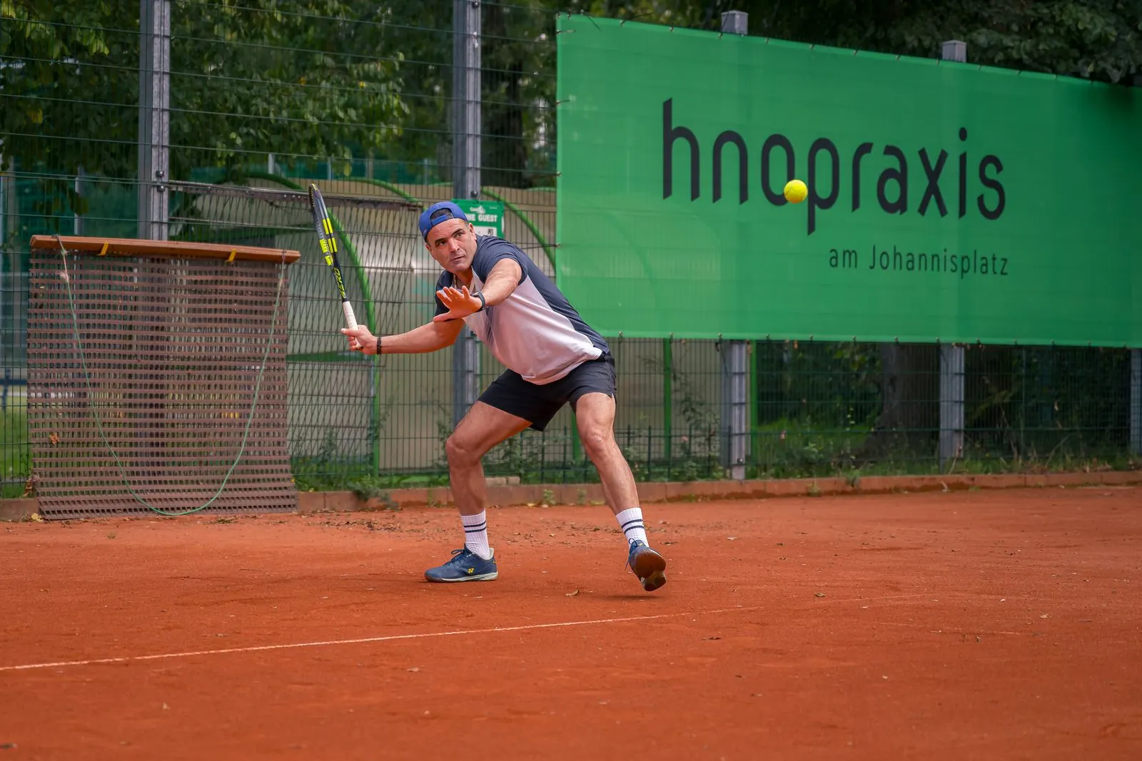 Shahin Shirzady spielt eine Vorhand auf dem Sandplatz